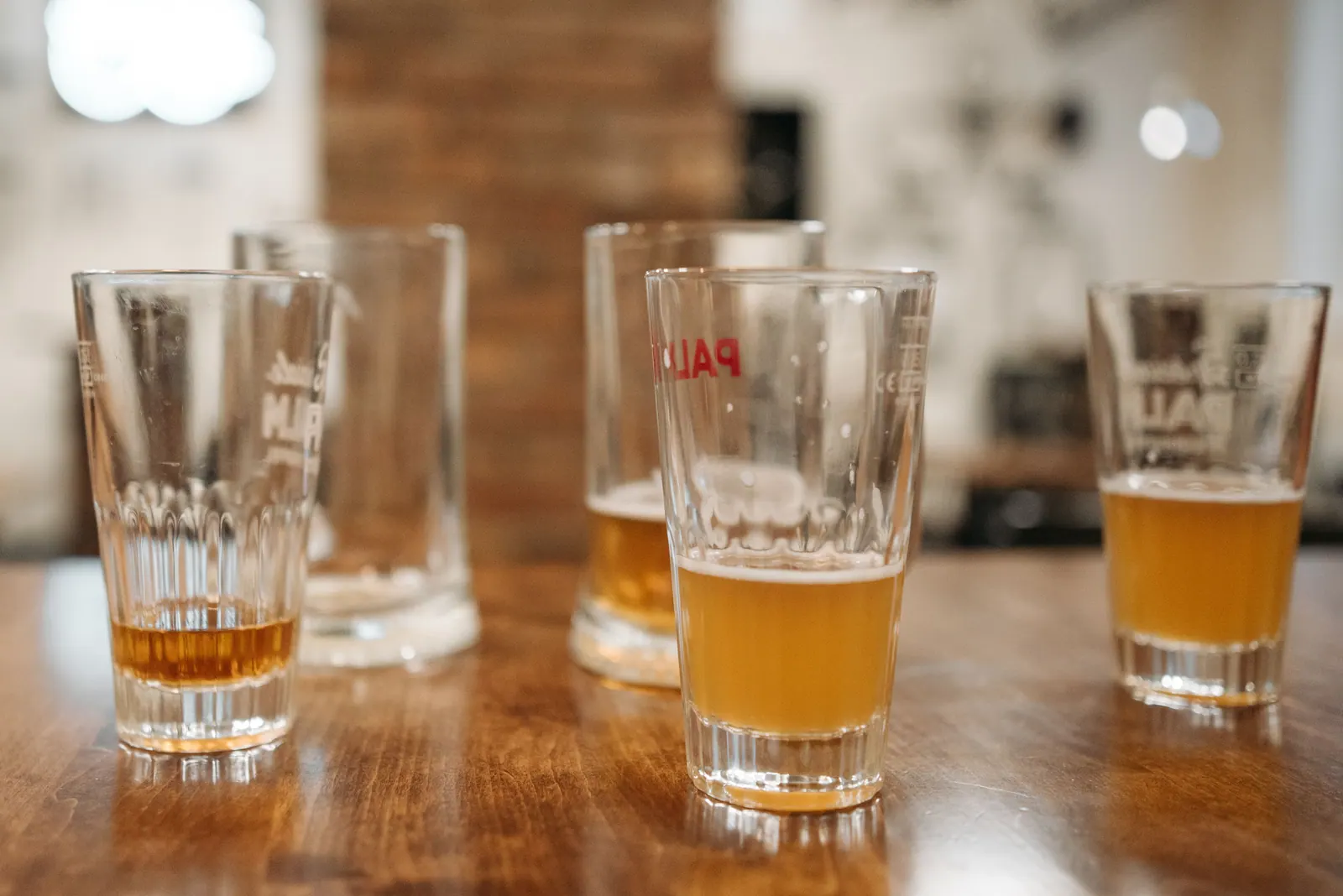 Glasses of beer on a wooden table.