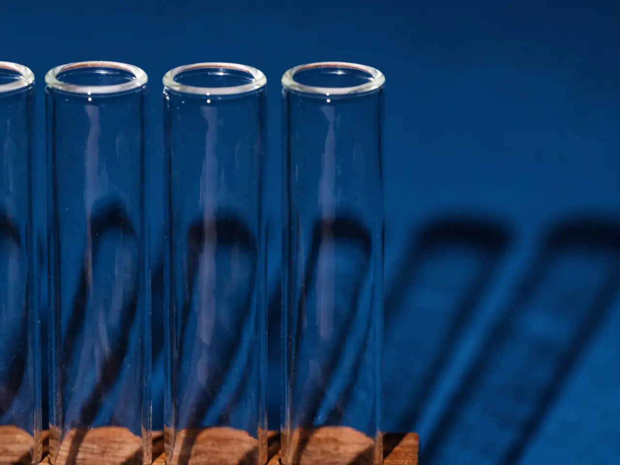 Glass sample tubes in a wooden rack under raking light in a UK laboratory