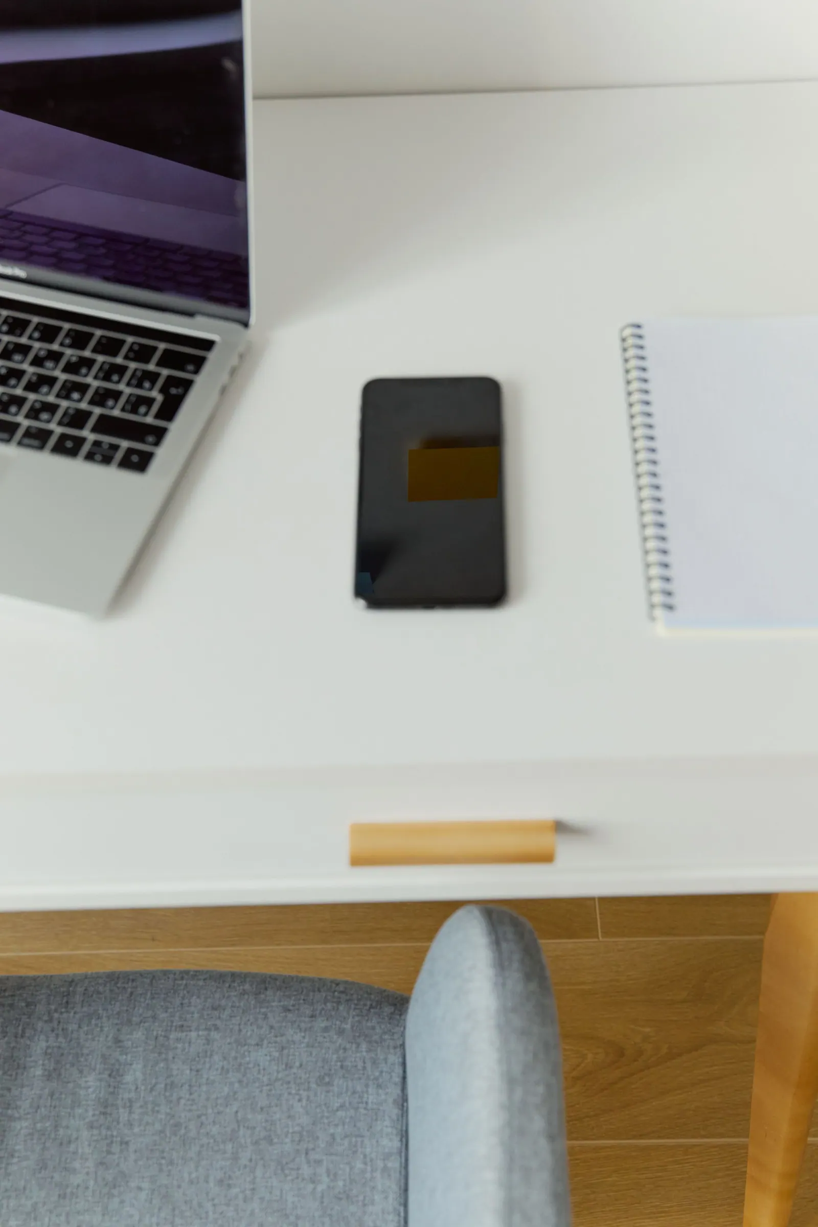 A smartphone and computer equipment on a desk.