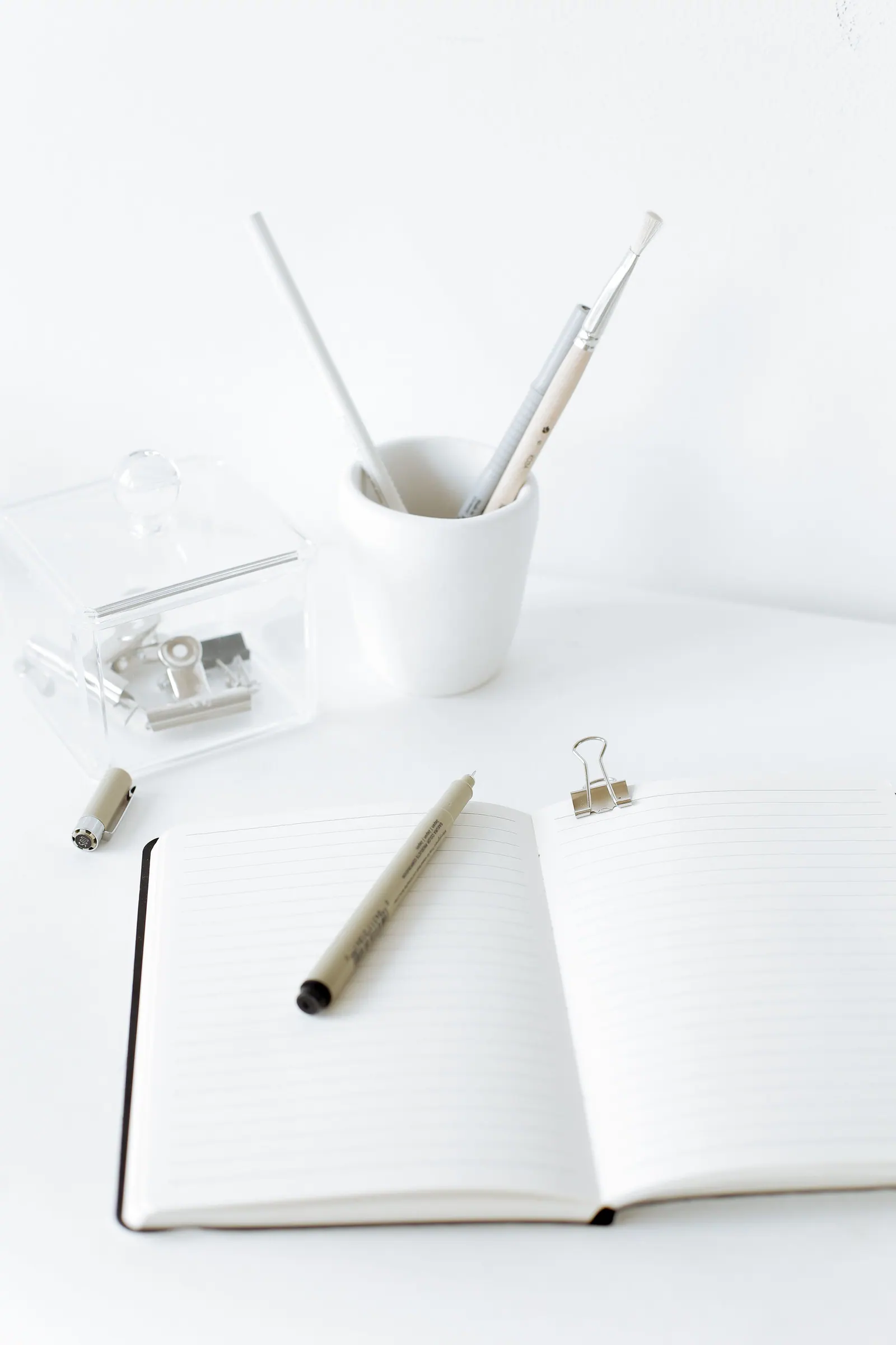 An open notebook and pen on a clear desk.