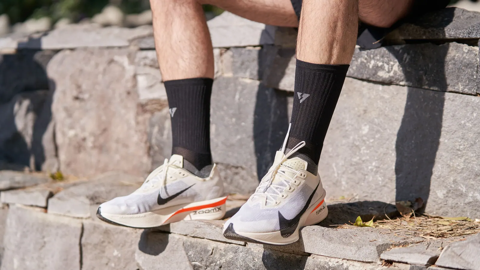 Walking shoes and lower legs on outdoor stone steps.