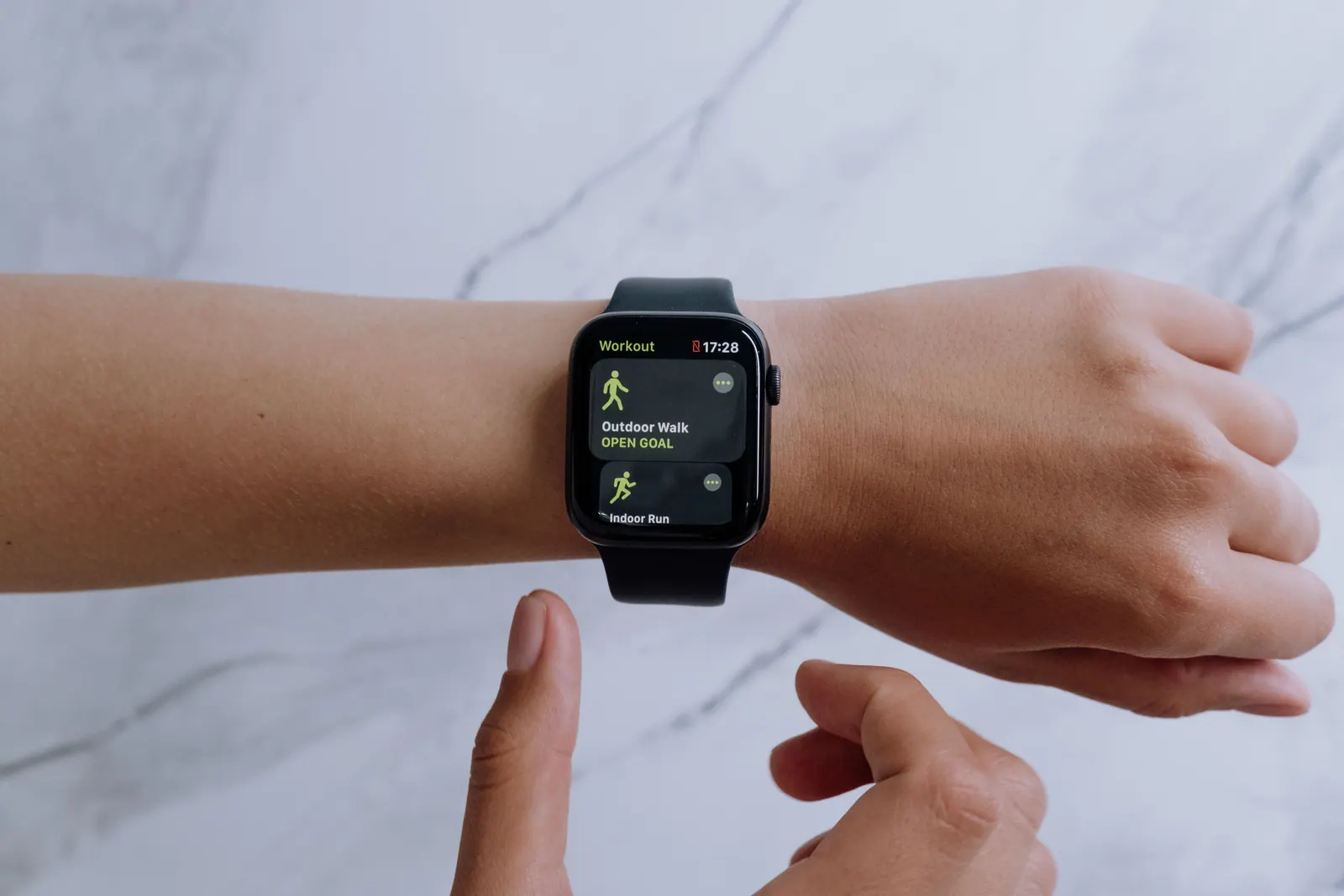 A smartwatch on a wrist showing its app screen.